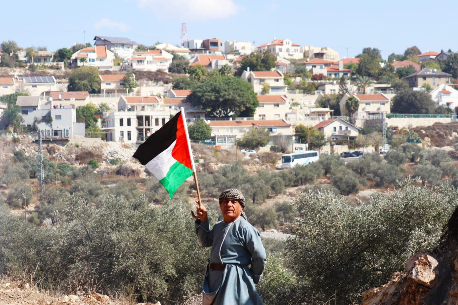 مواطن يرفع العلم الفلسطيني عقب قمع قوات الاحتلال لمسيرة كفر قدوم الأسبوعية شرق قلقيلية